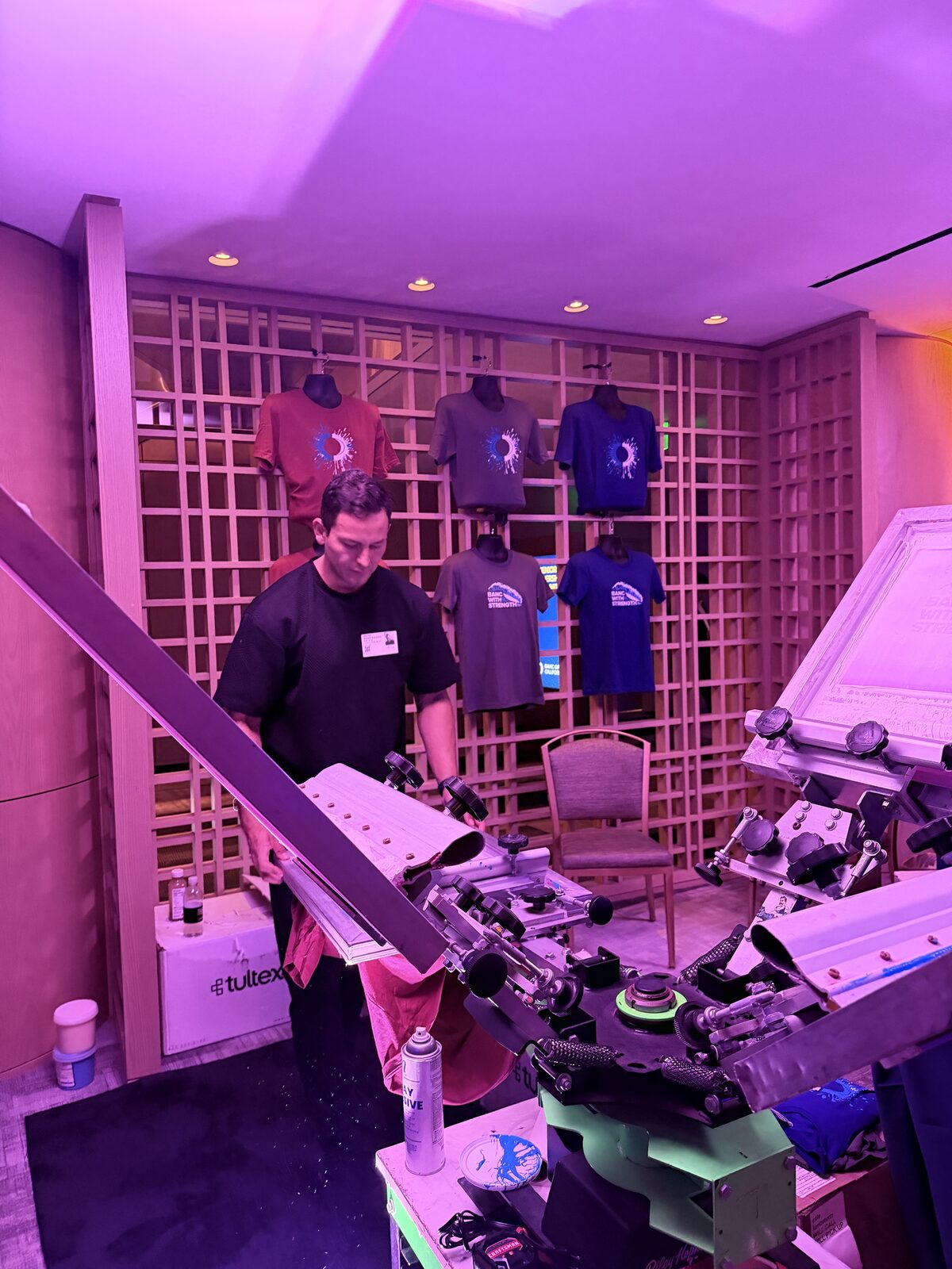 Operator loading a garment onto a screen press at a live wedding station
